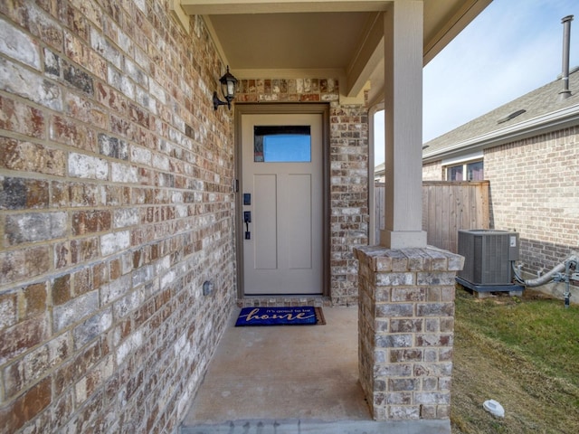 property entrance with cooling unit and brick siding