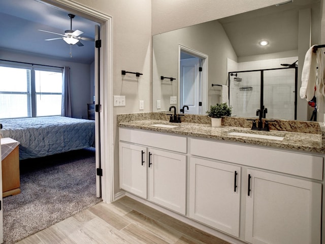 bathroom featuring hardwood / wood-style flooring, a shower with shower door, ceiling fan, and vanity