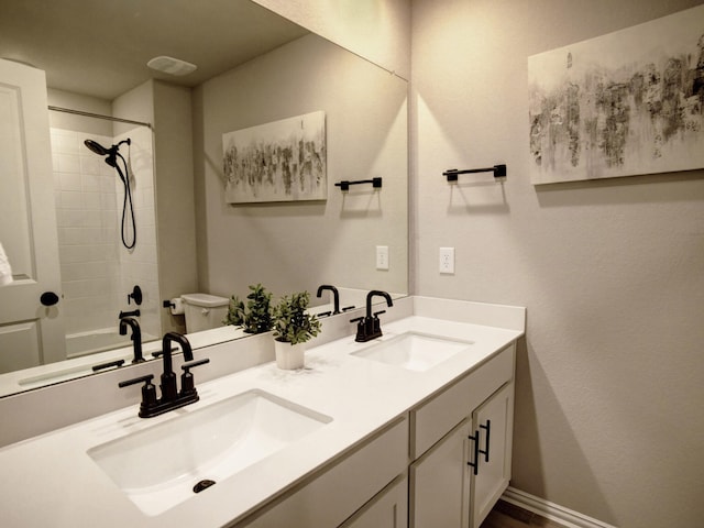 bathroom with toilet, vanity, and a tile shower