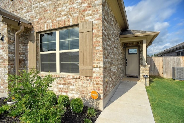 116 Shagbark Dr, Bastrop, TX 78602 - doorway to property with central AC and brick siding