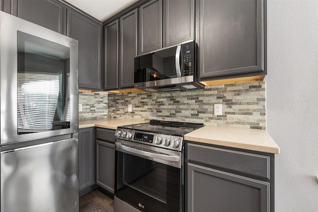 kitchen with decorative backsplash, dark wood-type flooring, and appliances with stainless steel finishes