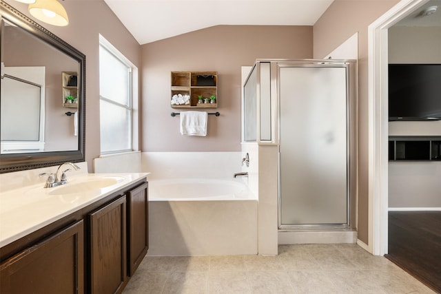 bathroom with vanity, separate shower and tub, and vaulted ceiling