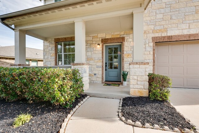 entrance to property featuring covered porch and a garage