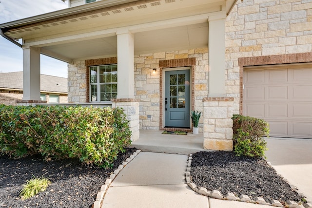 view of exterior entry featuring a garage and a porch