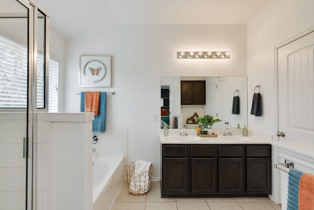 bathroom featuring tile patterned flooring, vaulted ceiling, separate shower and tub, and vanity