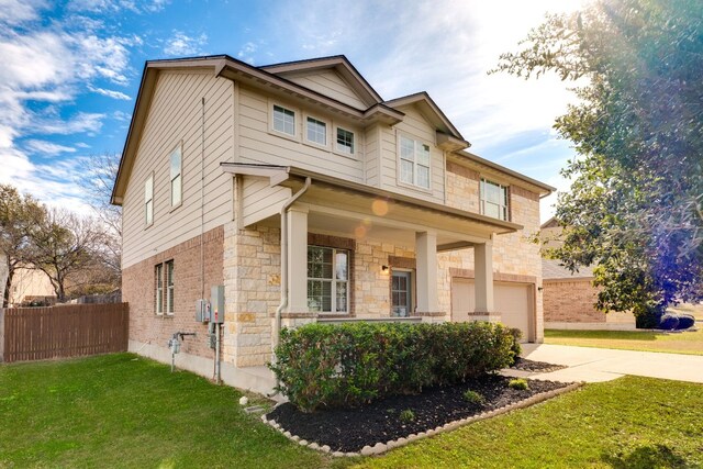 view of front of house with a garage, a front yard, and covered porch