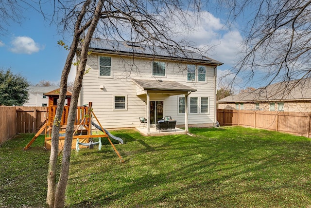 rear view of house with a yard, a patio area, and a playground