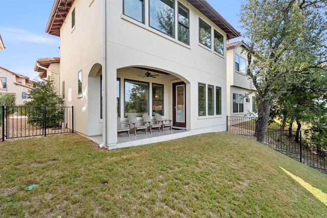 back of house with ceiling fan, a patio area, and a lawn