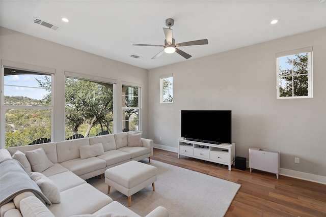 living room featuring ceiling fan and dark hardwood / wood-style flooring