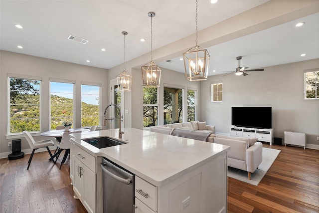 kitchen with ceiling fan, a center island with sink, sink, white cabinetry, and hanging light fixtures