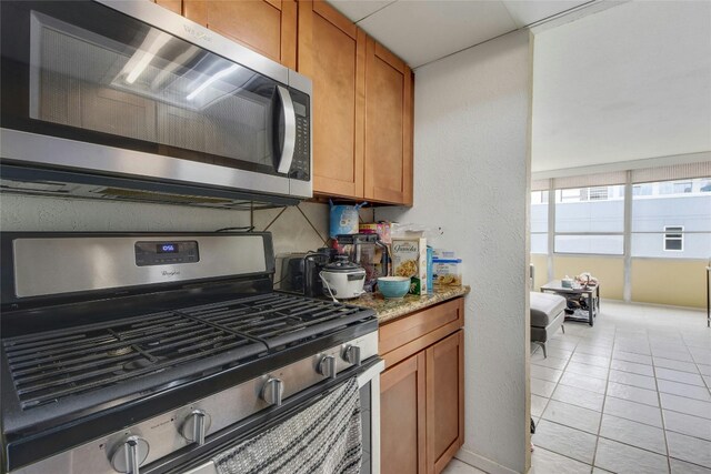 kitchen with appliances with stainless steel finishes and light tile patterned flooring