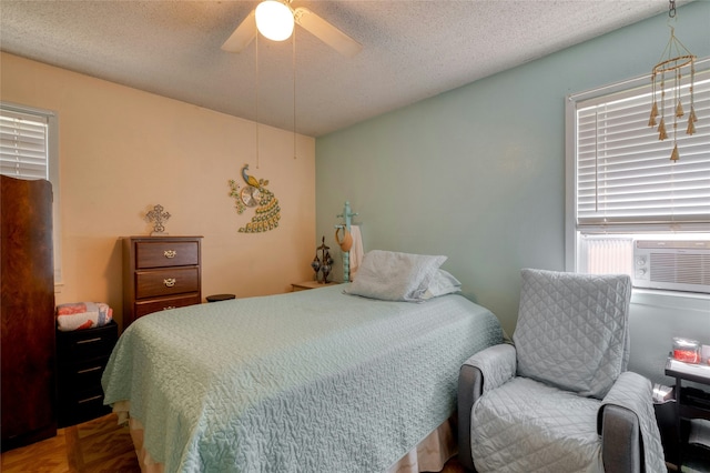 bedroom with ceiling fan, parquet flooring, cooling unit, and a textured ceiling