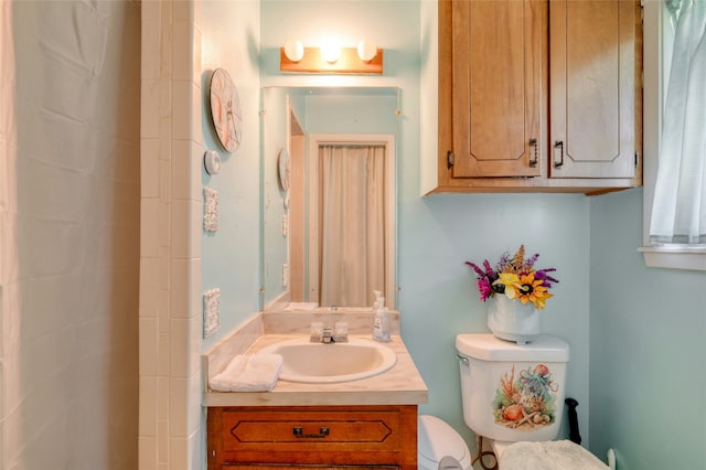 bathroom with toilet, vanity, and curtained shower