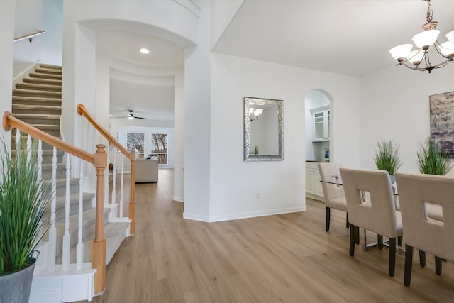 interior space featuring ceiling fan with notable chandelier and light hardwood / wood-style flooring