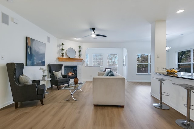 living room featuring ceiling fan and light hardwood / wood-style flooring