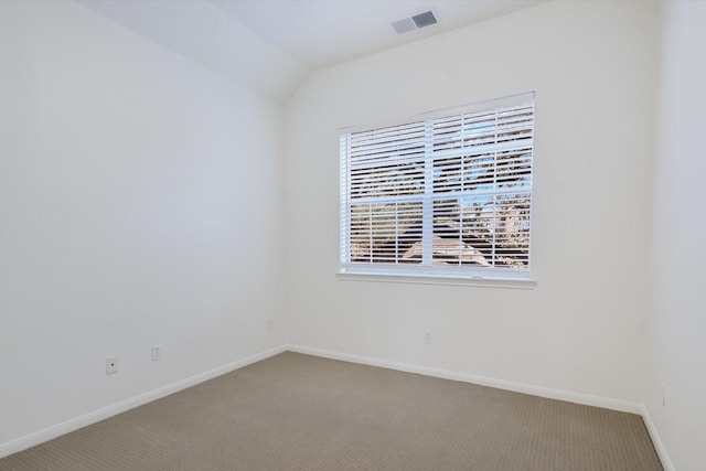 unfurnished room featuring carpet floors and vaulted ceiling