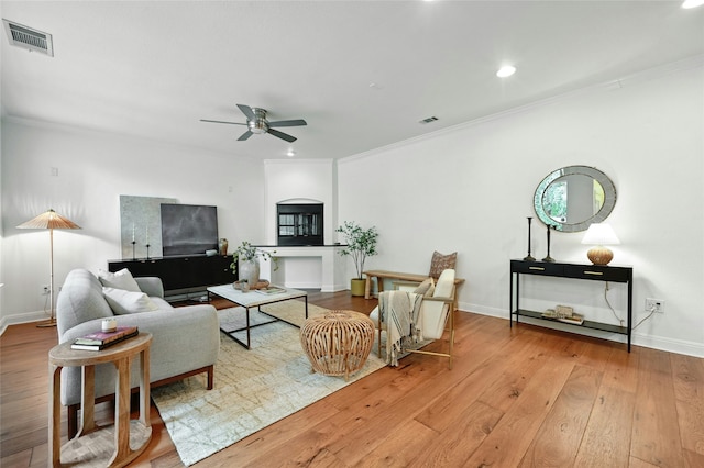 living room featuring ceiling fan, crown molding, and hardwood / wood-style flooring