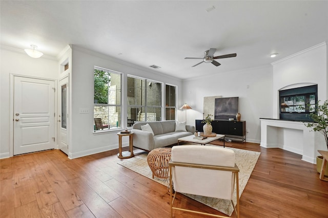 living room featuring ceiling fan, hardwood / wood-style floors, and crown molding