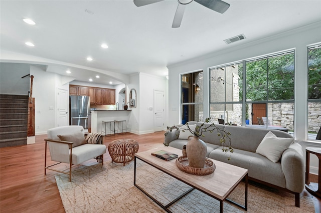 living room featuring ceiling fan, light hardwood / wood-style flooring, and crown molding