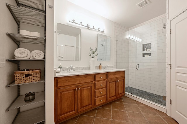 bathroom featuring tile patterned floors, an enclosed shower, and vanity