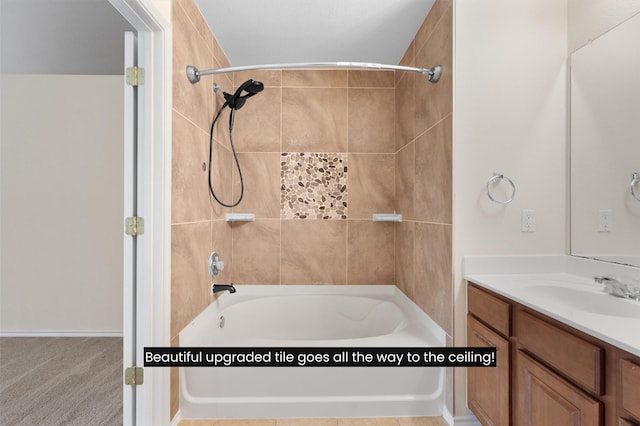 bathroom featuring tiled shower / bath and vanity