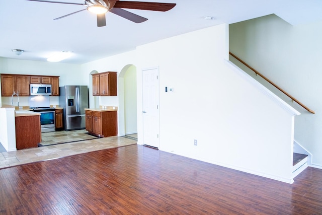 kitchen featuring ceiling fan, appliances with stainless steel finishes, and light wood-type flooring