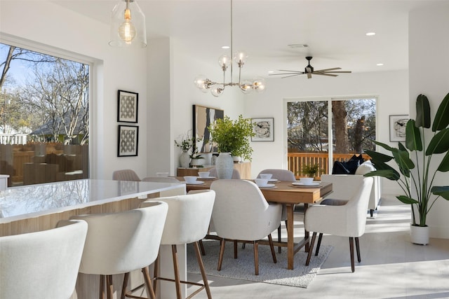 dining room with a healthy amount of sunlight and ceiling fan with notable chandelier