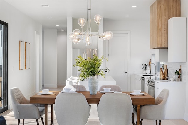 dining area featuring sink and a notable chandelier