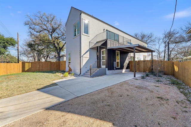 back of property with a yard and a balcony