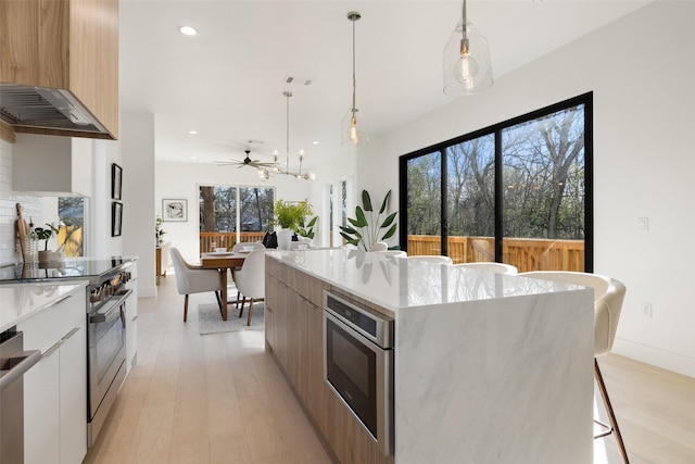 kitchen with a breakfast bar area, a kitchen island, white cabinetry, and pendant lighting