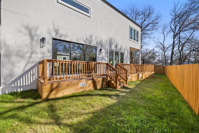 back of property featuring a deck and a lawn