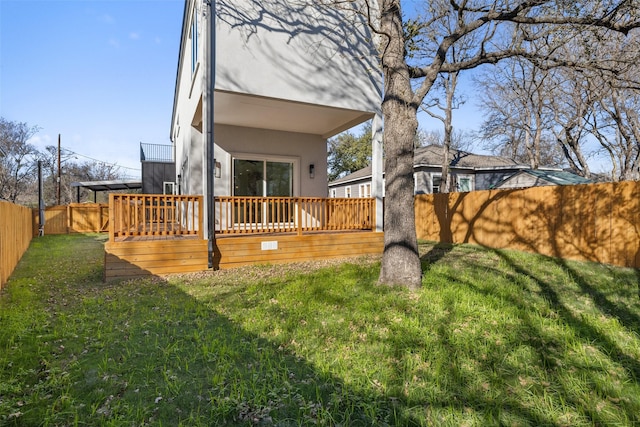 back of house featuring a deck and a lawn