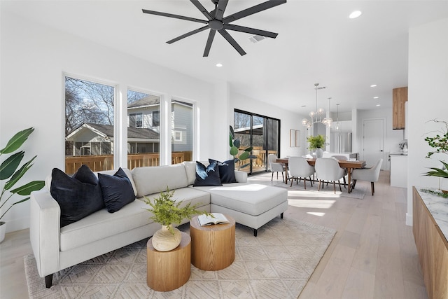 living room with ceiling fan and light hardwood / wood-style flooring