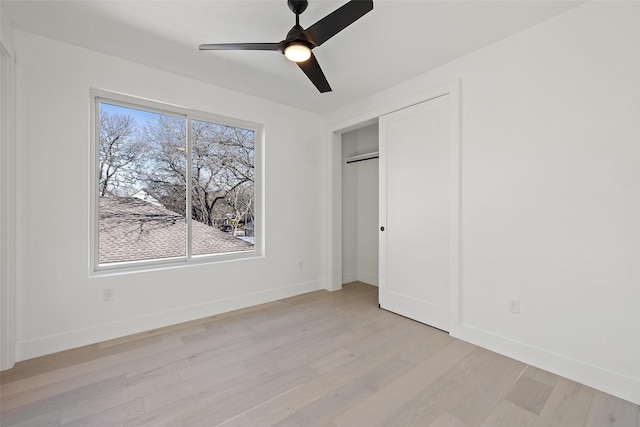 unfurnished bedroom featuring light wood-type flooring, ceiling fan, and a closet