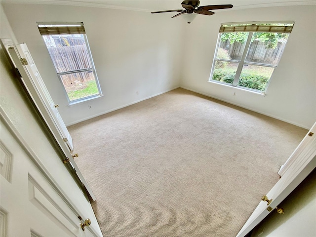 unfurnished room with light carpet, ceiling fan, and plenty of natural light