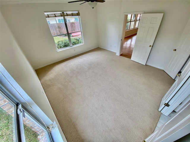 unfurnished room featuring ceiling fan and light carpet