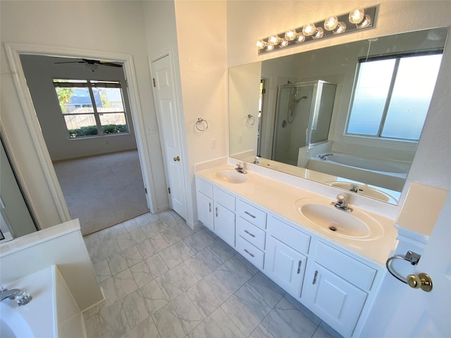 bathroom with ceiling fan, vanity, and shower with separate bathtub