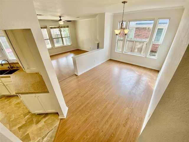 interior space with ceiling fan with notable chandelier, sink, light hardwood / wood-style flooring, and crown molding