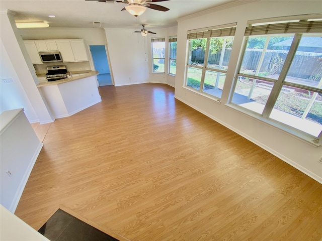 unfurnished living room with ceiling fan, ornamental molding, and light hardwood / wood-style flooring