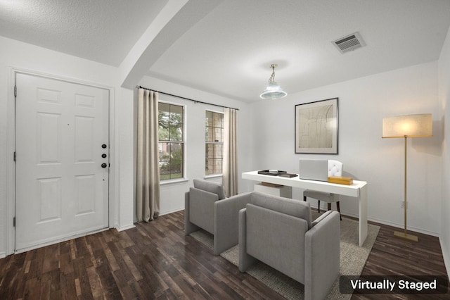 living room featuring dark hardwood / wood-style flooring and a textured ceiling