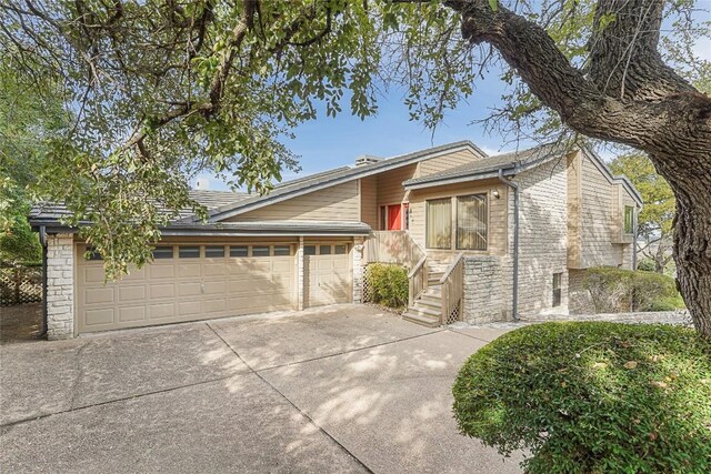 106 Firebird Cv, Lakeway, TX 78734 - view of front of house with concrete driveway, a garage, and stone siding