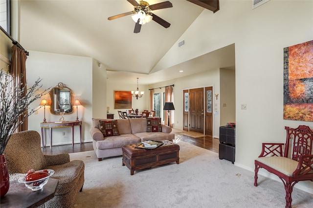 living room with high vaulted ceiling, carpet floors, and ceiling fan with notable chandelier