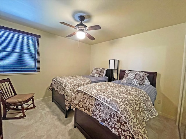 bedroom with light carpet, a ceiling fan, and baseboards