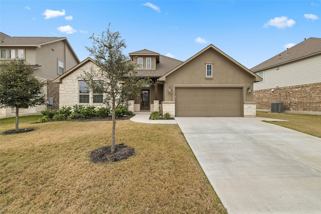 view of front of property with a front yard, central AC unit, and a garage