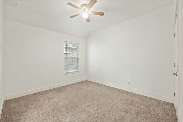 carpeted spare room featuring lofted ceiling and ceiling fan