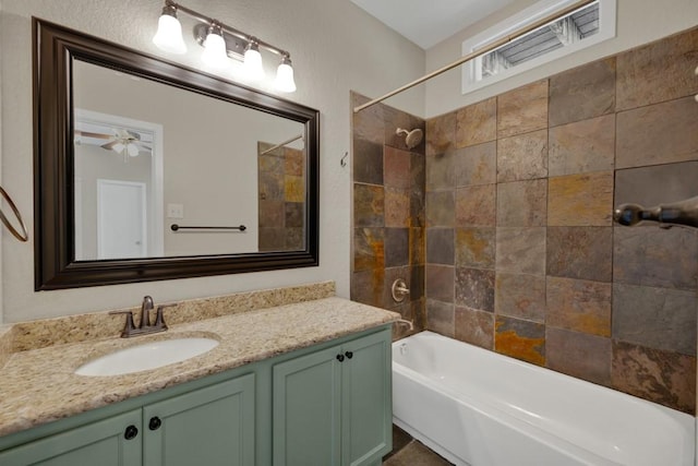 bathroom with tiled shower / bath combo and vanity