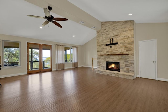 unfurnished living room featuring hardwood / wood-style flooring, a stone fireplace, high vaulted ceiling, and ceiling fan