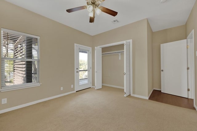 unfurnished bedroom featuring ceiling fan, a closet, and light carpet