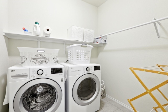 laundry room with washer and dryer and light tile patterned floors