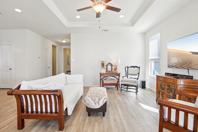 bedroom with a raised ceiling, ceiling fan, light wood-type flooring, and ornamental molding